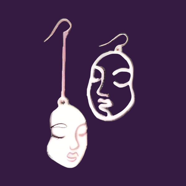 Pair of face-shaped earrings on a black background